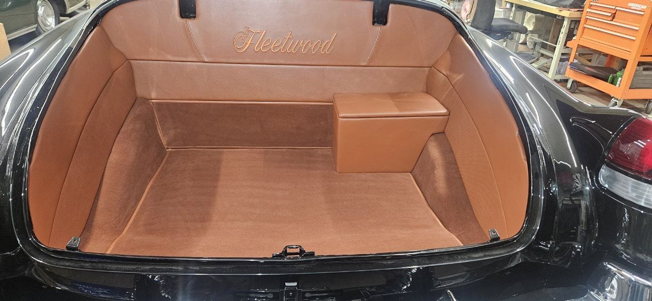 Trunk upholstered in cognac leather and carpet, with Fleetwood embroidered on the back panel