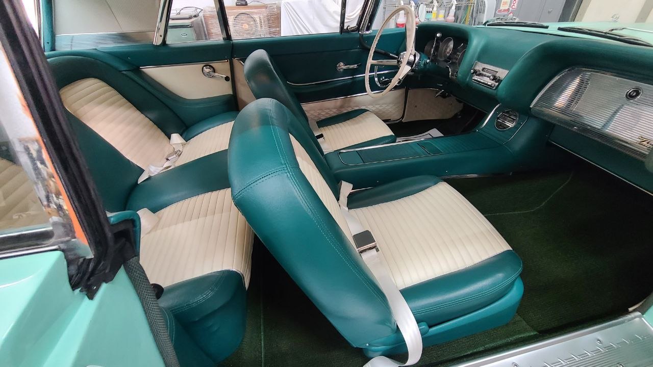 Restored Thunderbird interior: teal and white pleated bucket seats, console and dash